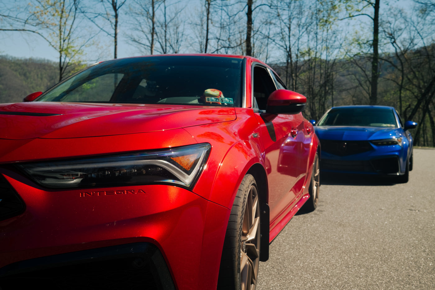 A 5th generation Acura Integra alongside an 11th gen Honda Civic, showing the Integra daytime running light signature