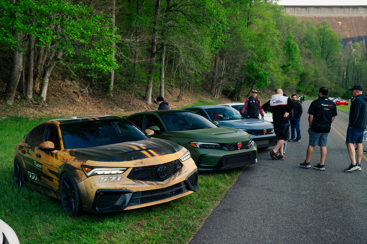 A Civic Type R and an Acura Integra Type S parked with other cars at a meet on a mountain road