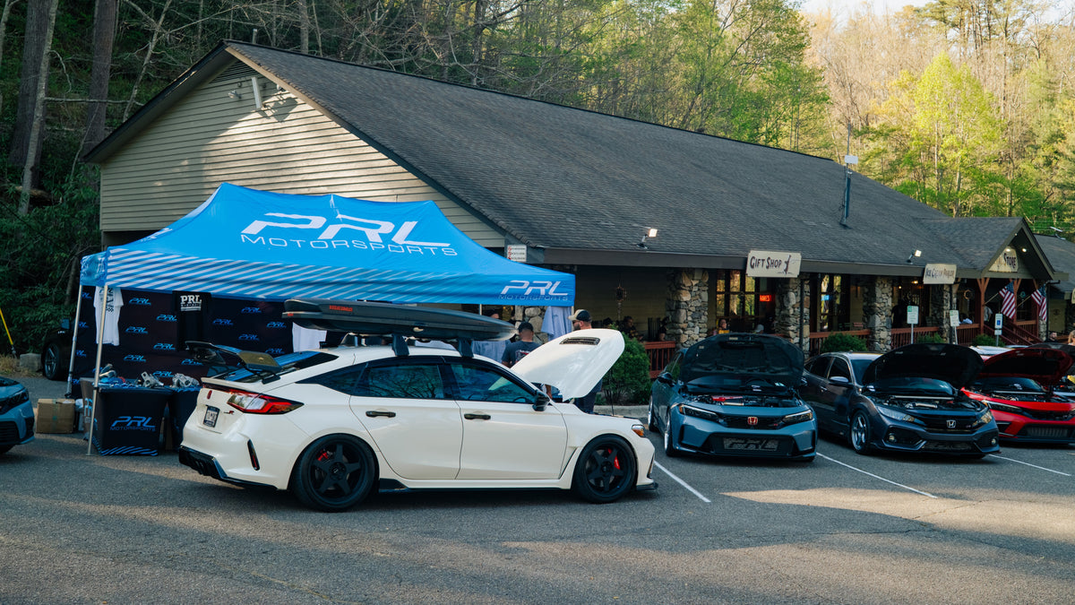 The PRL Motorsports booth at Wake the Dragon 2026, with their Civic Type R and a line of Civics alongside