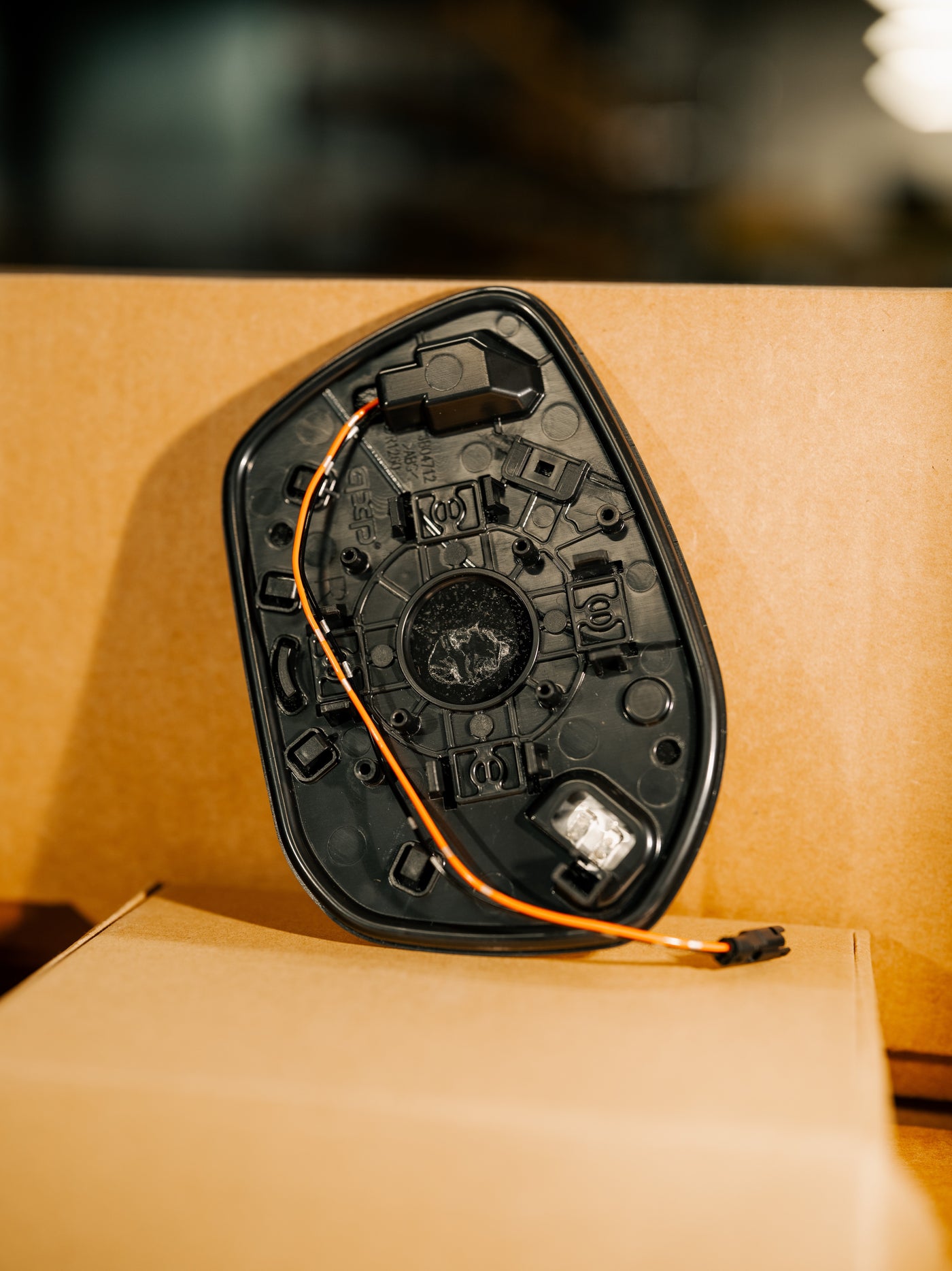 Back of the TSP mirror glass showing the integrated heating element and the factory-style wiring connector