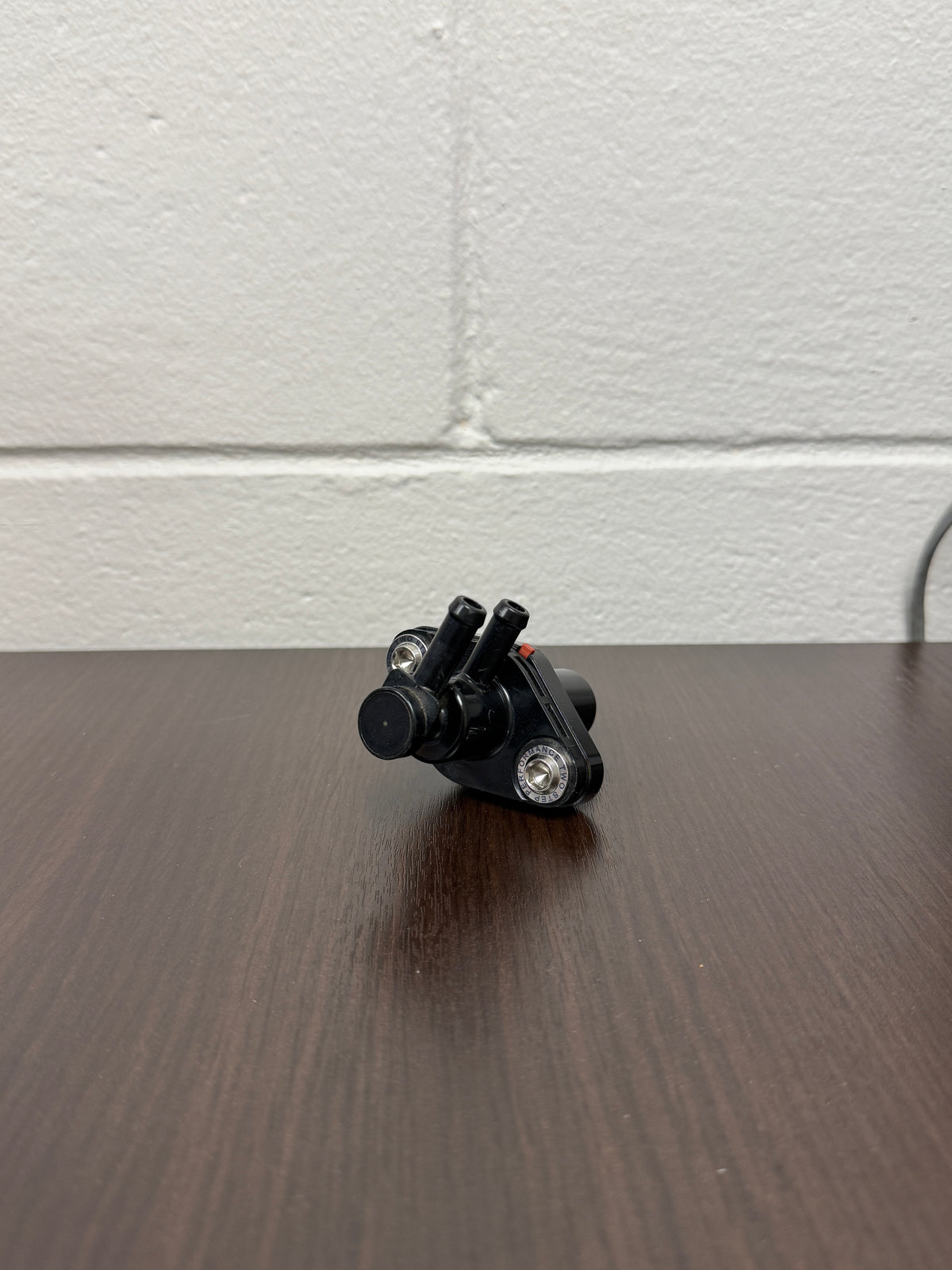 The factory EVAP valve mounted on the TSP billet aluminum adapter with titanium screws