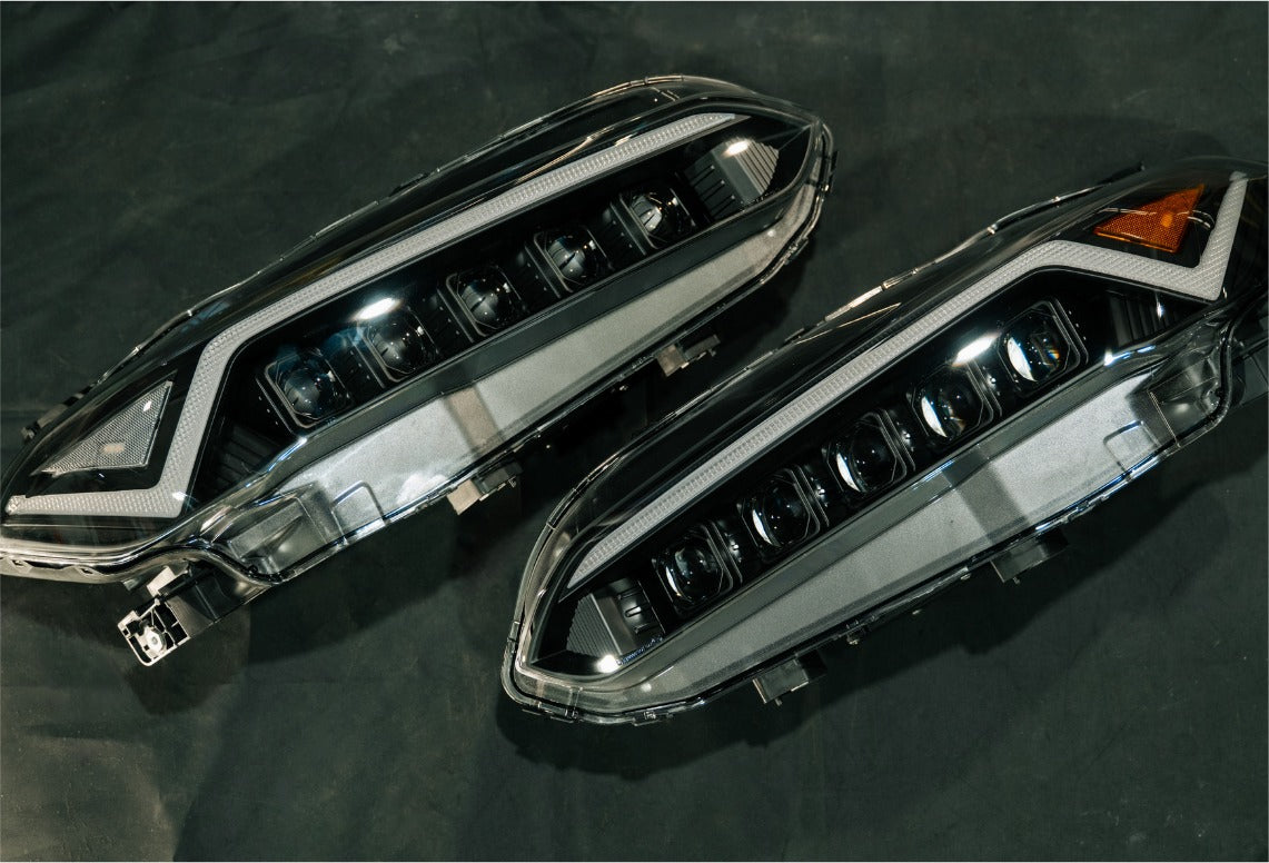 A pair of TSP Senko Series LED headlights, clear side marker on the left and amber on the right